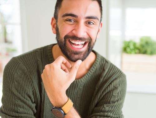 man in green sweater smiling | dental crowns beaverton or
