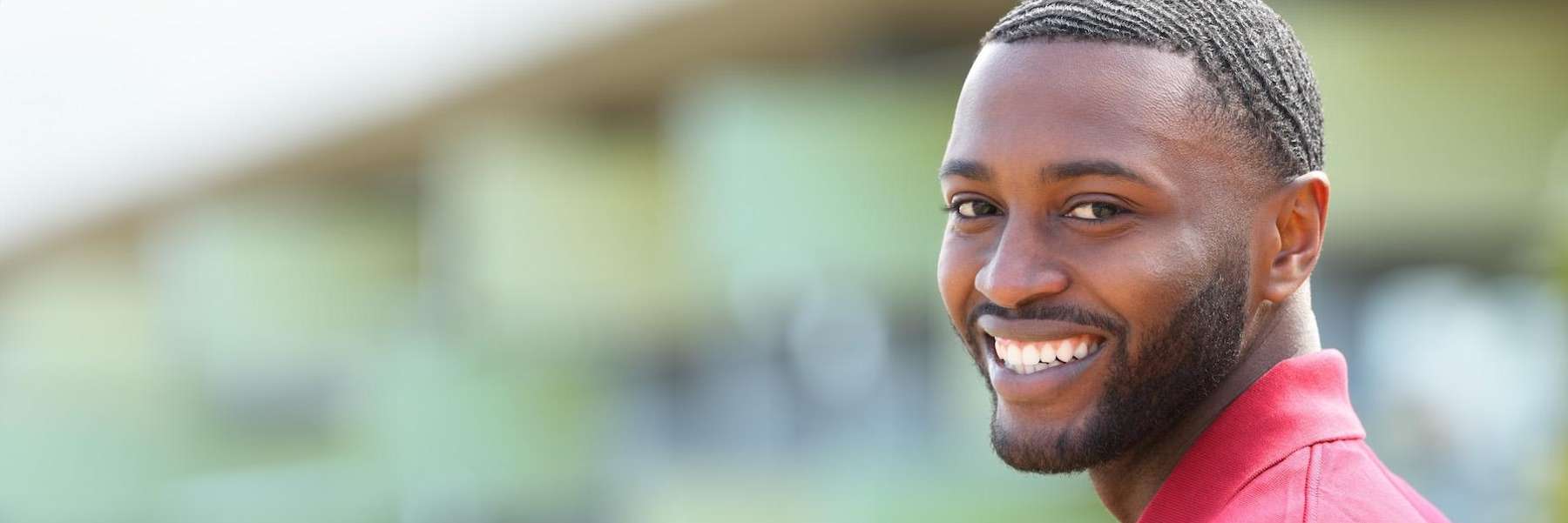 man in red shirt smiling | tooth extraction beaverton or